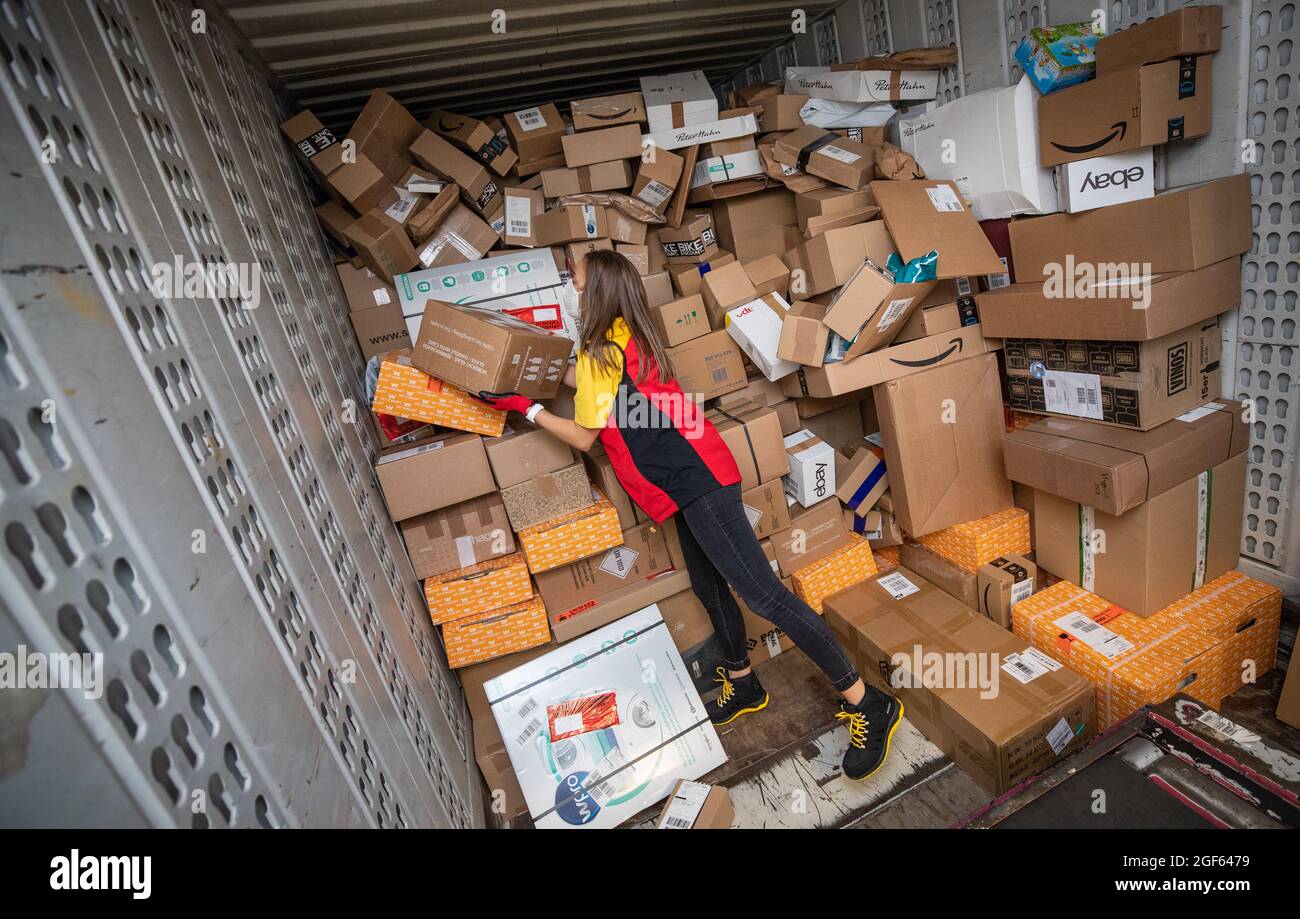 19. August 2021, Baden-Württemberg, Köngen: Adriana Tec, Dispatcher im DHL Paketzentrum in Köngen, verlädt während ihrer Nachtschicht Pakete von einem Lkw auf eine Montagelinie. (An dpa: 'Hohes Paketvolumen im DHL-Distributionszentrum - Corona oder nicht') Foto: Christoph Schmidt/dpa Stockfoto