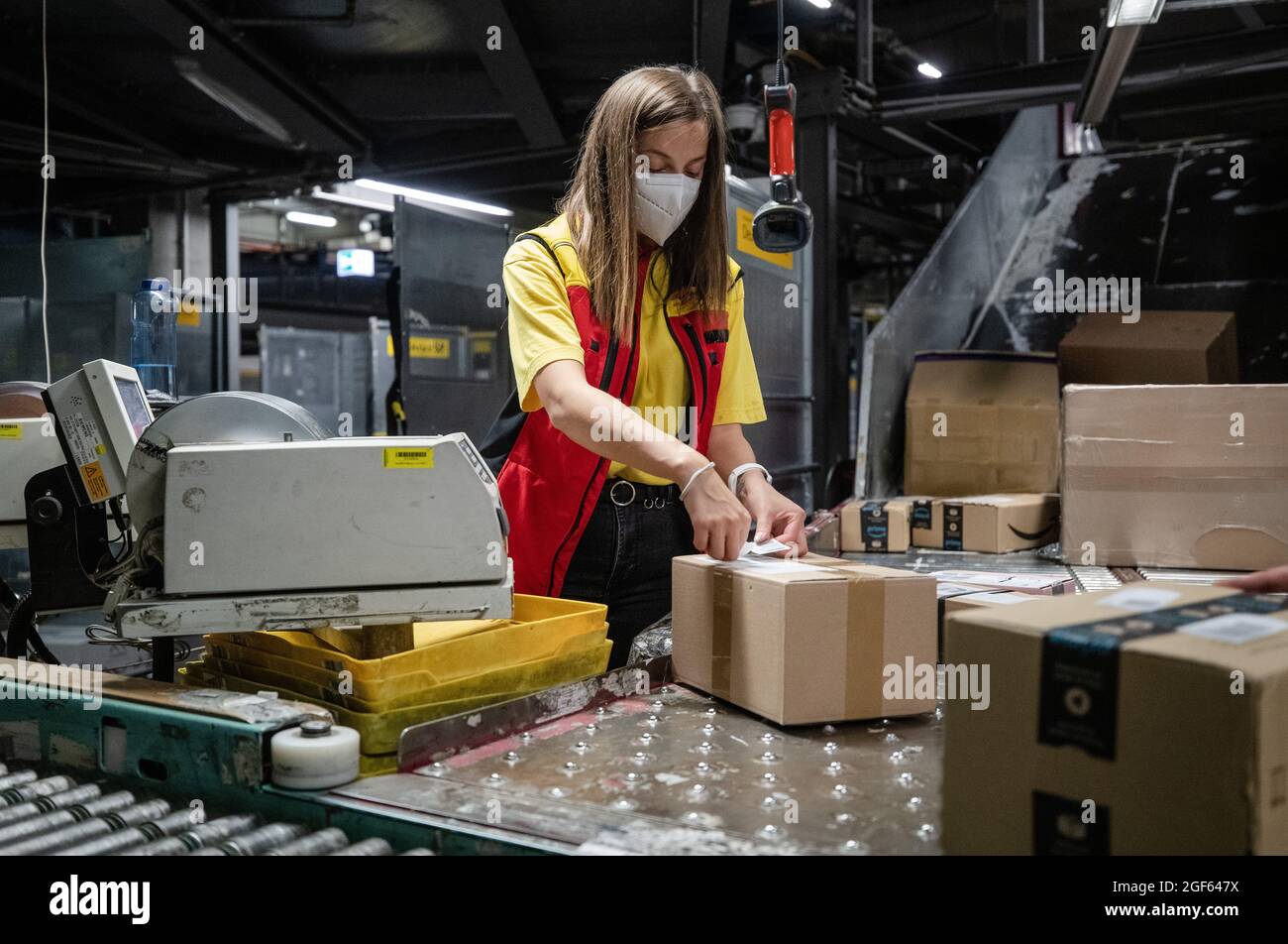 19. August 2021, Baden-Württemberg, Köngen: Adriana Tec, Dispatcher im DHL Paketzentrum in Köngen, scannt während ihrer Nachtschicht Barcodes auf Pakete. (An dpa: 'Hohes Paketvolumen im DHL-Distributionszentrum - Corona oder nicht') Foto: Christoph Schmidt/dpa Stockfoto