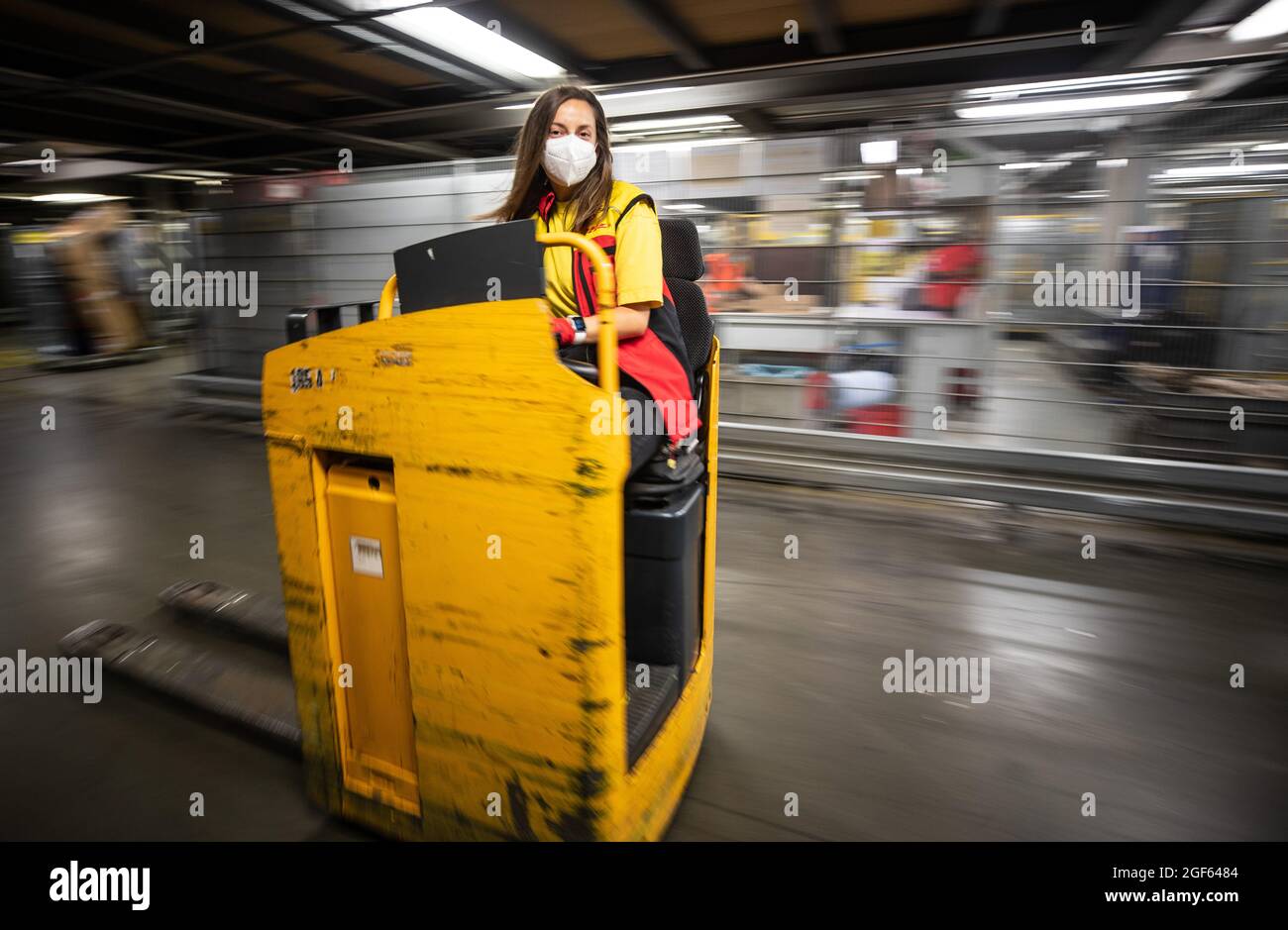 19. August 2021, Baden-Württemberg, Köngen: Adriana Tec, Dispatcher im DHL Paketzentrum in Köngen, fährt in ihrer Nachtschicht eine Stablere durch das Paketzentrum. (An dpa: 'Hohes Paketvolumen im DHL-Distributionszentrum - Corona oder nicht') Foto: Christoph Schmidt/dpa Stockfoto