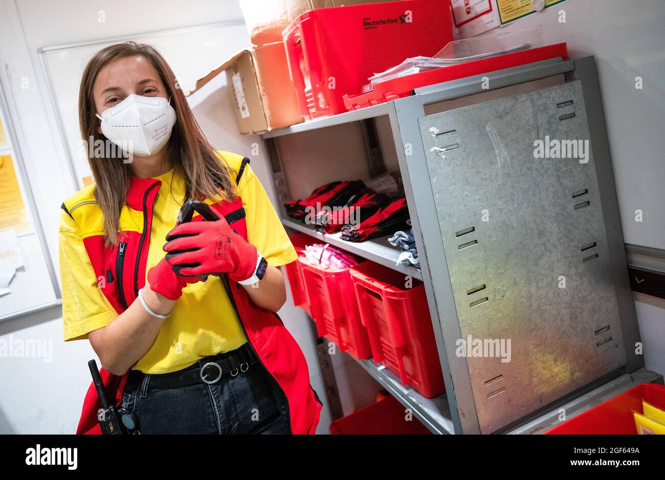19. August 2021, Baden-Württemberg, Köngen: Adriana Tec, Dispatcher im DHL Paketzentrum in Köngen, zieht zu Beginn ihrer Nachtschicht Arbeitshandschuhe an. (An dpa: 'Hohes Paketvolumen im DHL-Distributionszentrum - Corona oder nicht') Foto: Christoph Schmidt/dpa Stockfoto
