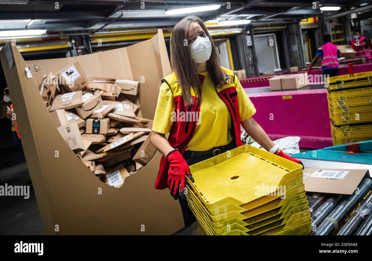 19. August 2021, Baden-Württemberg, Köngen: Adriana Tec, Dispatcher im DHL Paketzentrum in Köngen, platziert Pakete während ihrer Nachtschicht auf einer Montagelinie (an dpa: 'Hohes Paketvolumen im DHL-Versandzentrum - Corona or not') Foto: Christoph Schmidt/dpa Stockfoto