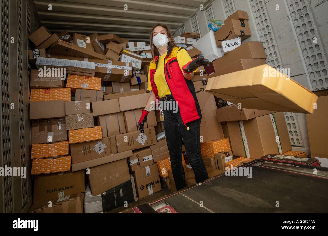19. August 2021, Baden-Württemberg, Köngen: Adriana Tec, Dispatcher im DHL Paketzentrum in Köngen, verlädt während ihrer Nachtschicht Pakete von einem Lkw auf eine Montagelinie. (An dpa: 'Hohes Paketvolumen im DHL-Distributionszentrum - Corona oder nicht') Foto: Christoph Schmidt/dpa Stockfoto