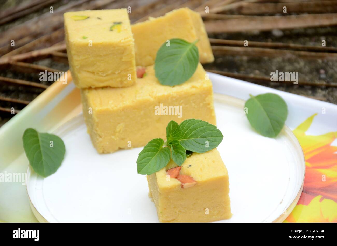 Nahaufnahme des Bündels gelb Gramm Mehl süß mit grüner Minze über unscharf weiß braun Hintergrund. Stockfoto