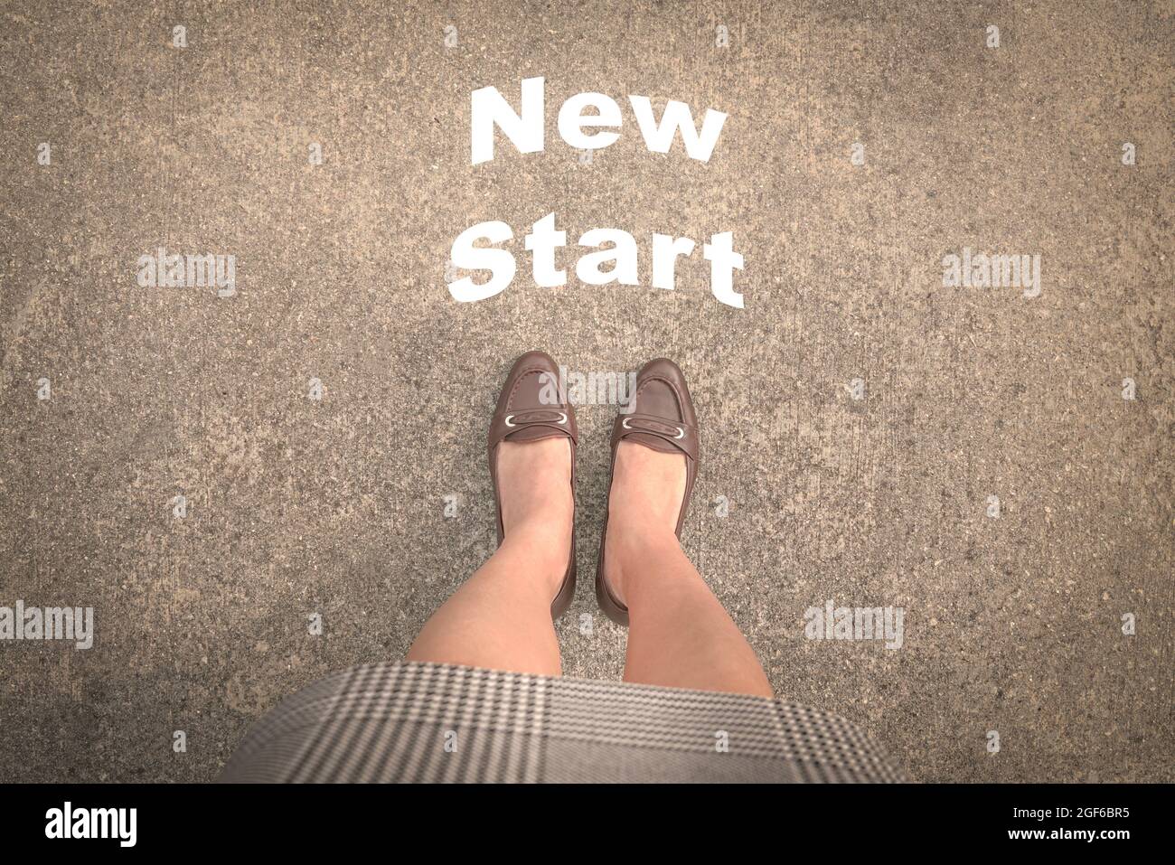 Frau, die mit Worten auf der Straße steht, New Start vor ihr. Draufsicht. Stockfoto