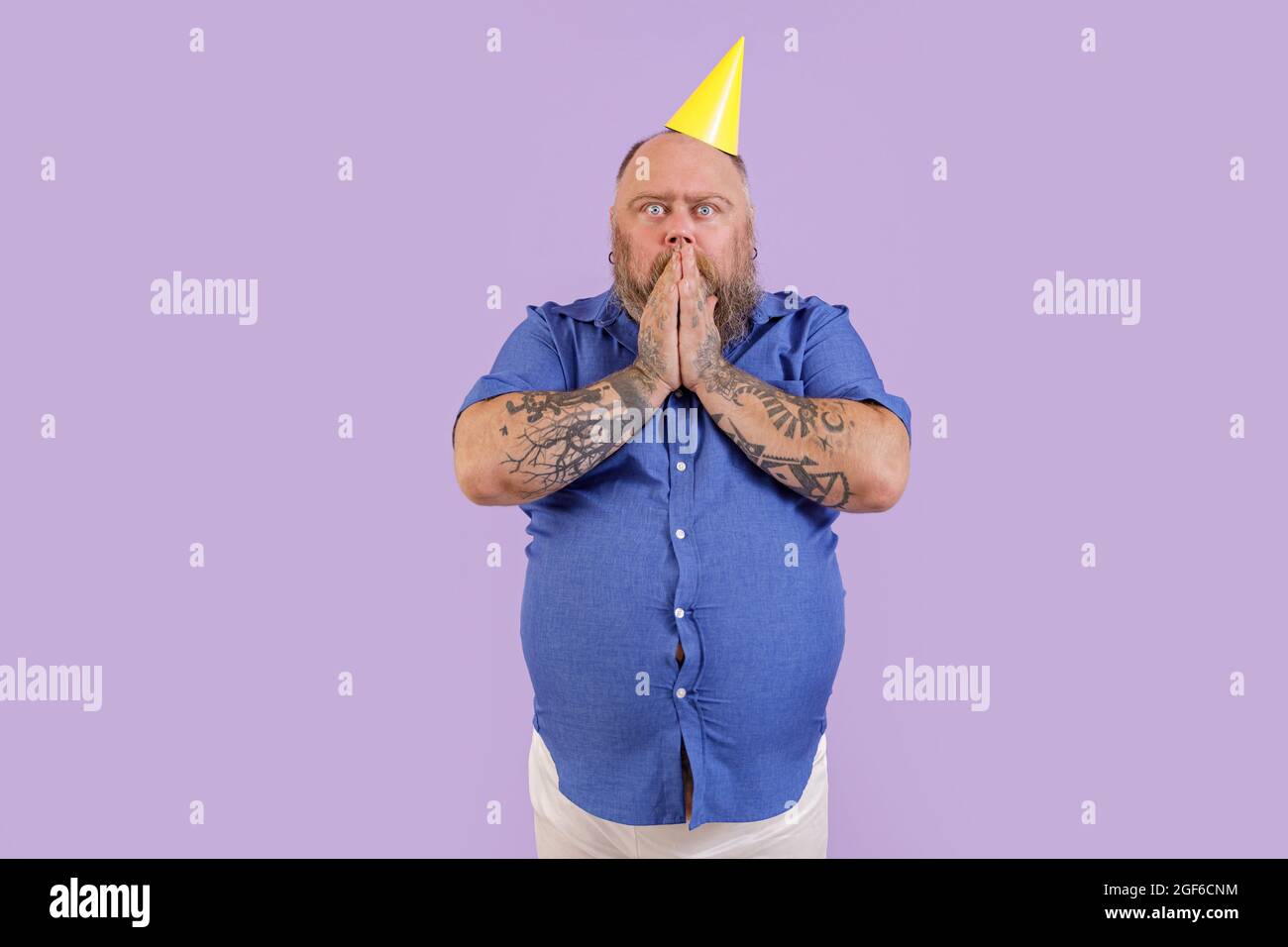 Überrascht Mann mit Übergewicht in engen Hemd hält Hände über den Mund auf lila Hintergrund Stockfoto