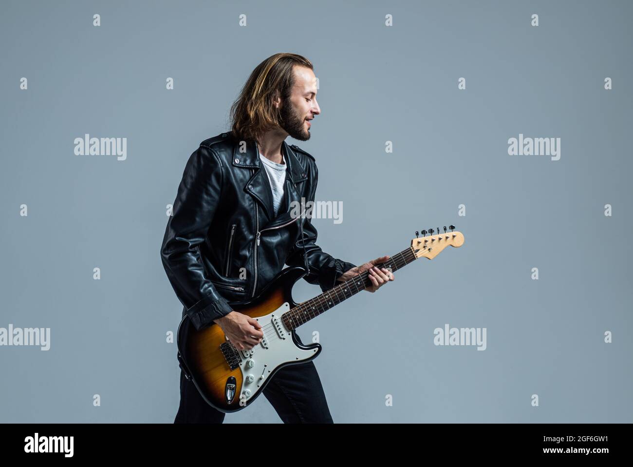 Bärtiger Rockmusiker spielt E-Gitarre in Lederjacke, Musiker Stockfoto