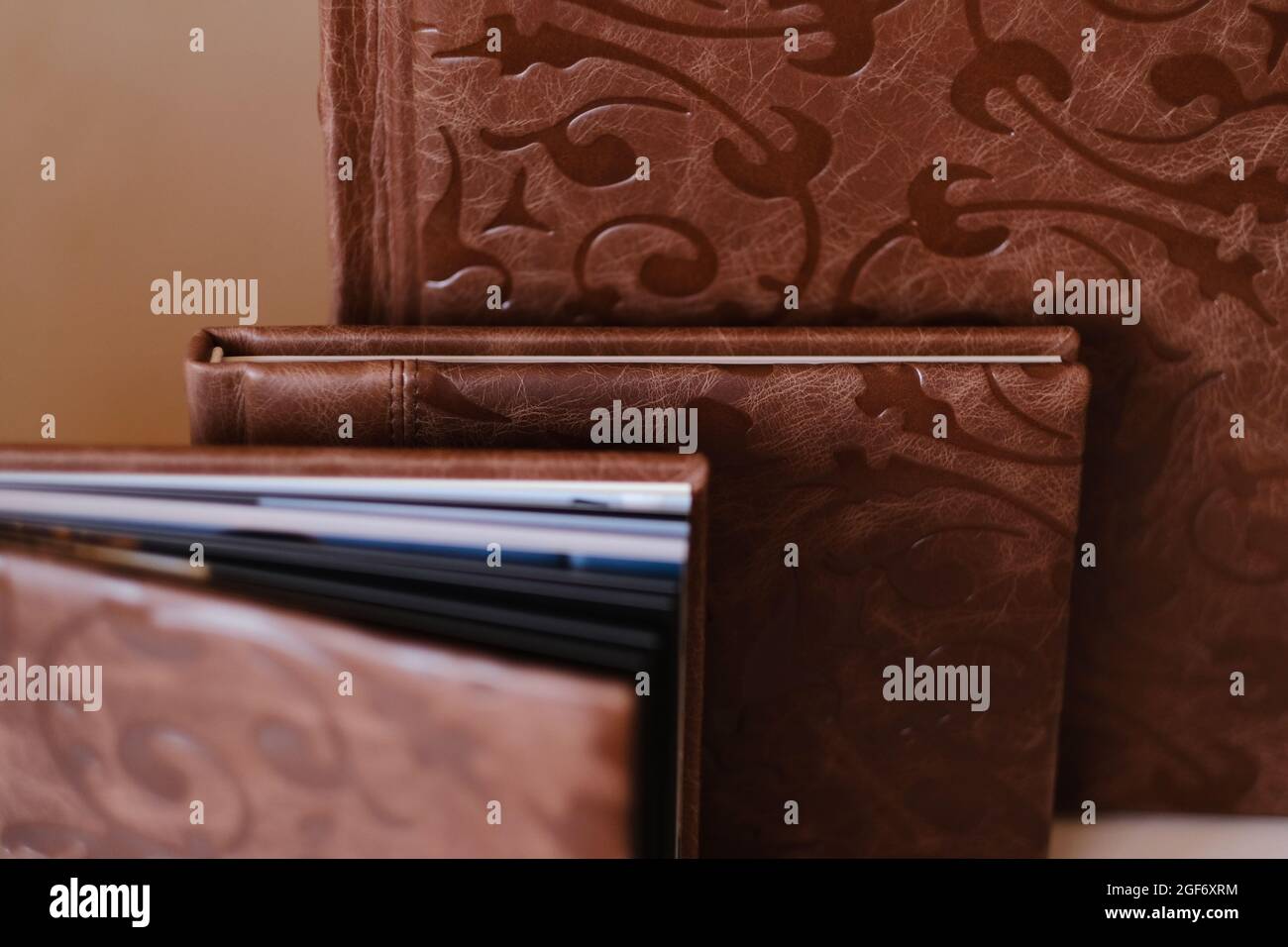 Komposition von Fotobüchern aus natürlichem braunem Leder in verschiedenen Größen. Fragment einer Fotobuch-Bindung Stockfoto