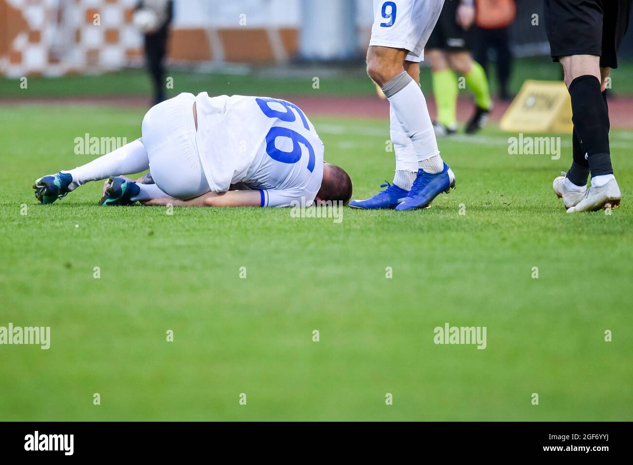 Der verletzte Fußballspieler liegt auf dem Spielfeld. Stockfoto