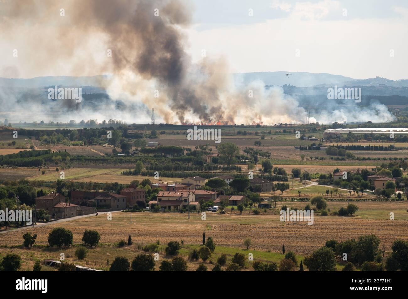 Feuerlöschhubschrauber kämpft mit Sommerbrand in der Toskana, Italien, von Castiglion Fiorentino aus gesehen, 21/08/2021 Stockfoto