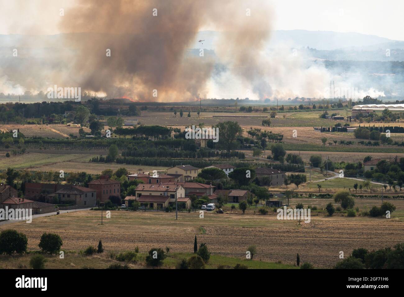 Feuerlöschhubschrauber kämpft mit Sommerbrand in der Toskana, Italien, von Castiglion Fiorentino aus gesehen, 21/08/2021 Stockfoto