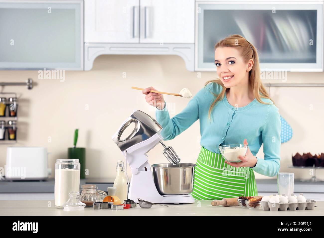 Junge Frau, die einem Küchenmaschine Mehl zu einem Teig für Männer  hinzufügt Stockfotografie - Alamy