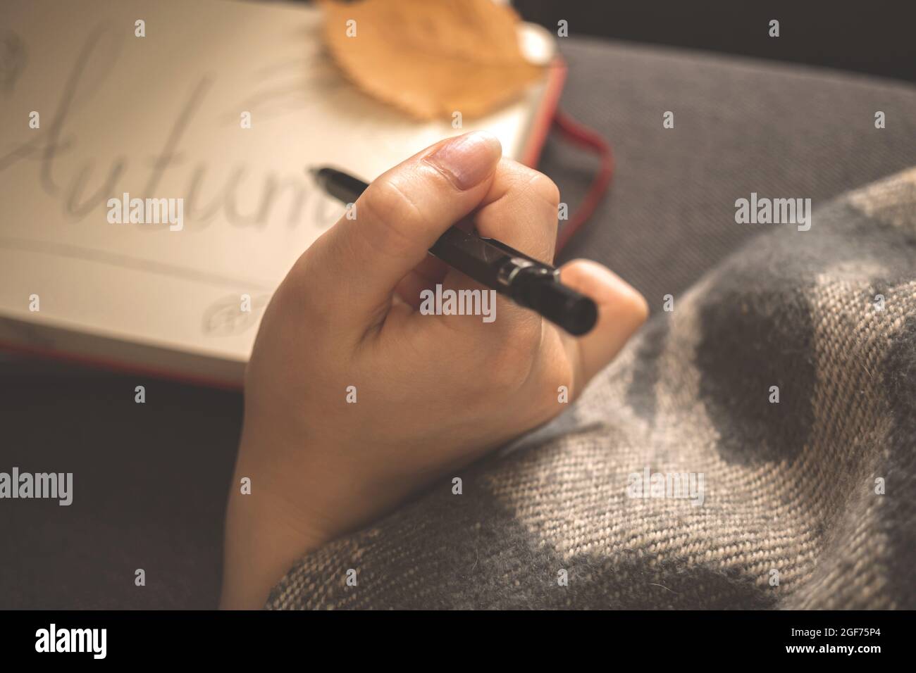 Gemütliches Haus und Herbsturlaub Hintergrund. Hand mit Bleistift oder Stift. Foto des Hygge-Konzepts Stockfoto