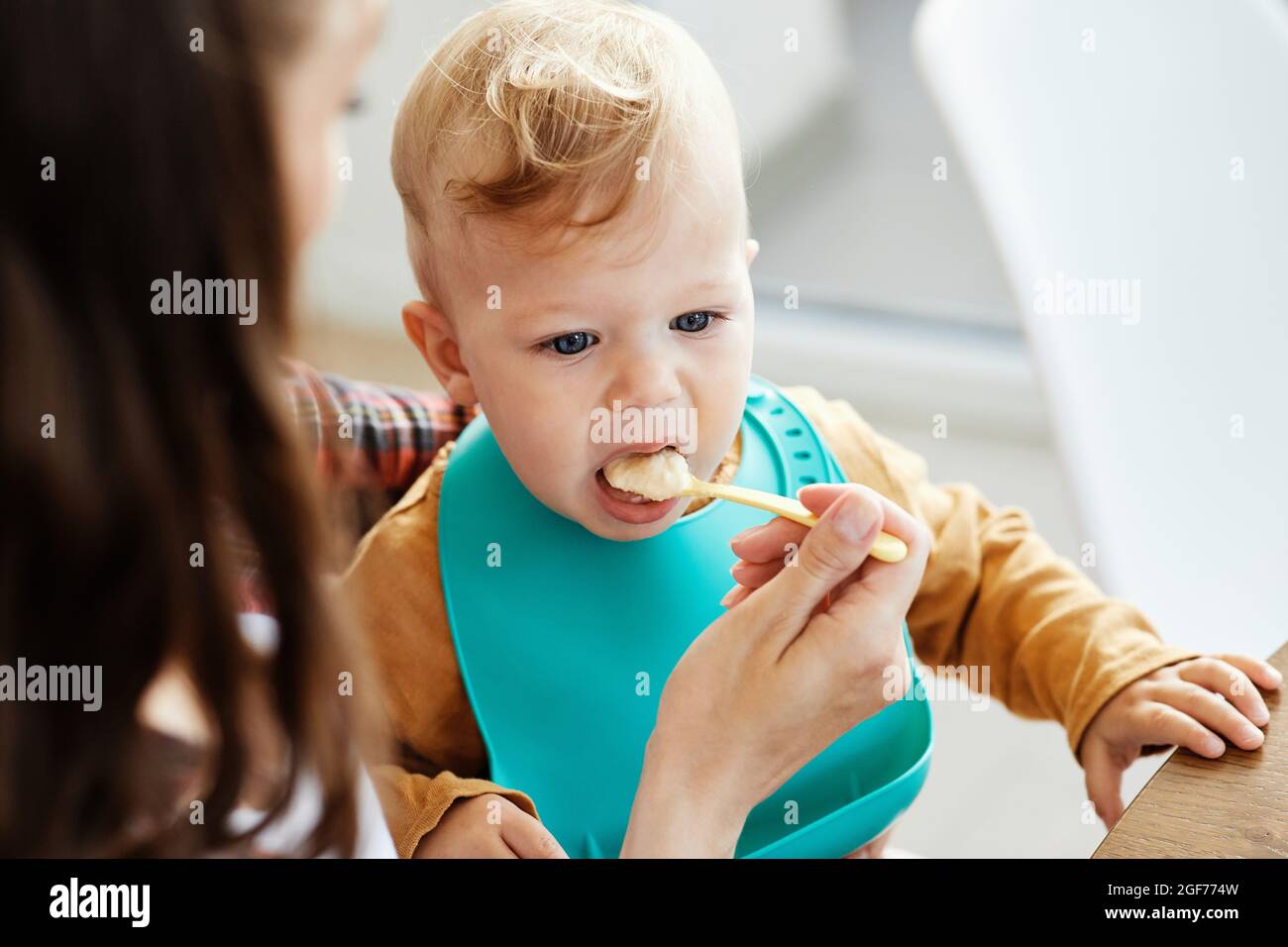 Mutter Fütterung Babynahrung Kind essen Familienpflege Kindheit niedlichen Löffel Stockfoto