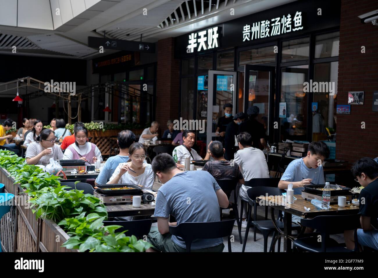 Gäste genießen Gourmetspeisen in einem Straßenrestaurant mit lokaler Küche von Guizhou Stockfoto