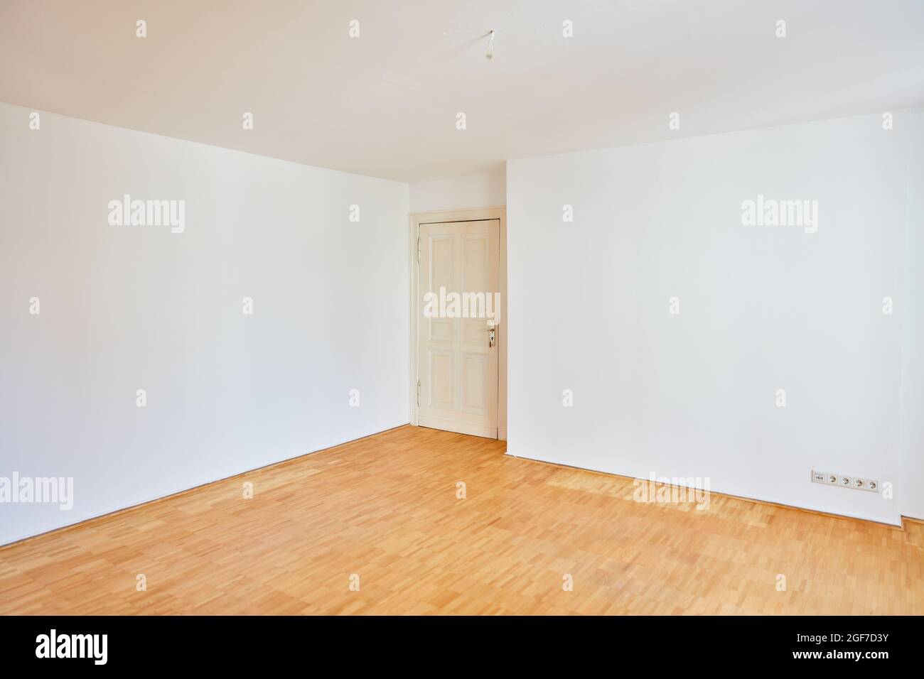 Ecke mit alter Gebäudetür in einem leeren Raum mit Parkett im alten Gebäude Stockfoto