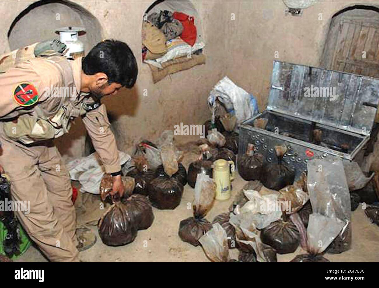 OPIUMCACHE ein afghanischer Polizist inspiziert einen Opiumcache, der in einem sicheren Haus der Taliban im Dorf Babaji in der Provinz Helmand, Afghanistan, gefunden wurde, 7. Mai 2009. Foto: CPL Sean Harp, US Army. Stockfoto