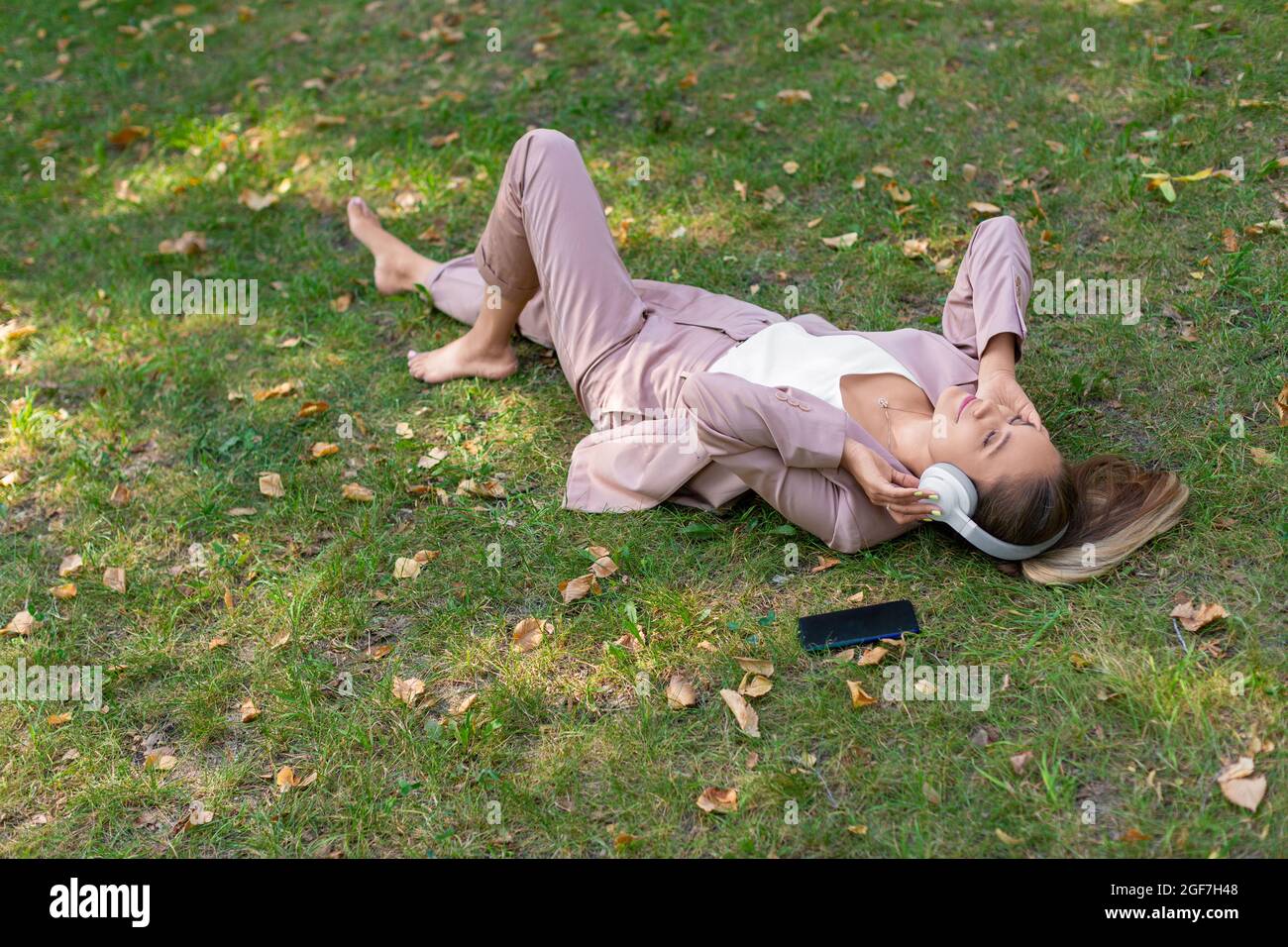 Frau im Gras genießt die Musik - Draufsicht. Stockfoto