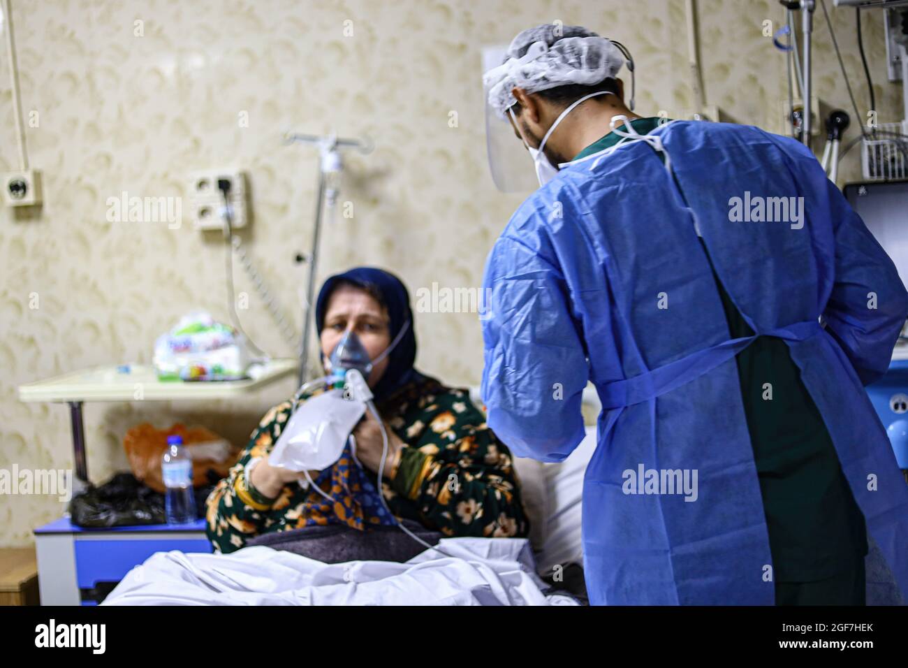 Idlib, Syrien. August 2021. Ein Arzt in Schutzkleidung kümmert sich um eine ältere Frau, die an einer Delta-Mutation in einem Isolationskrankenhaus in Idlib leidet.die Delta-Mutante kam in Idlib an, wo im Idlib-Labor 92 Proben genotypisiert wurden. Die Alpha-Mutante wurde in 6 Proben und die Delta-Mutante in 47 Proben gefunden, und es gibt einen signifikanten Anstieg der Anzahl der bestätigten Fälle von Covid-19 in den letzten Tagen. (Bild: © Omar Albam/SOPA Images via ZUMA Press Wire) Stockfoto