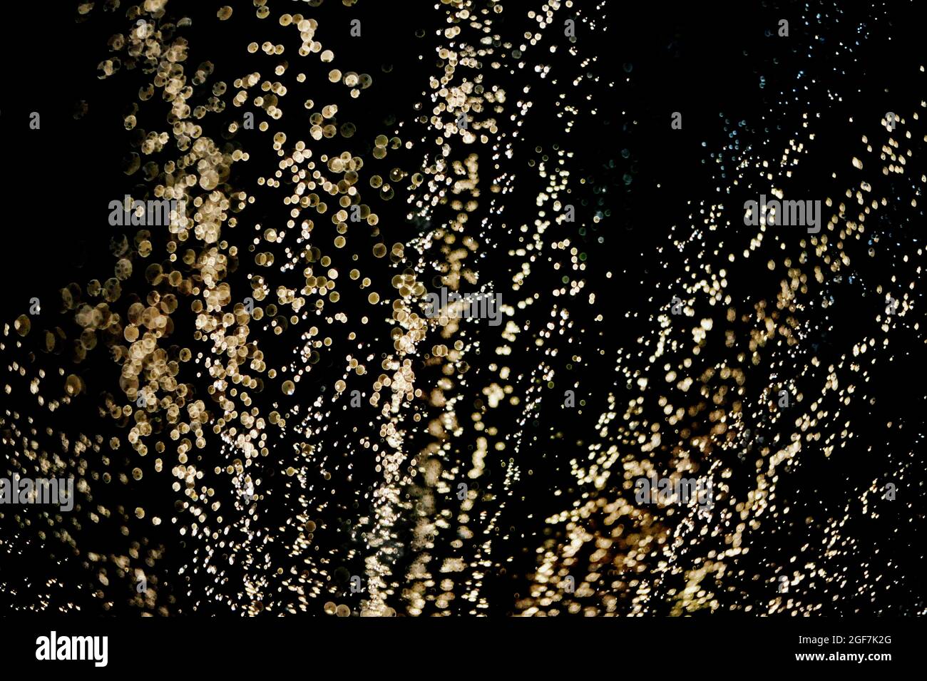 Wassertropfen fliegen in eine Richtung, Wassertropfen schweben auf verschwommenem Hintergrund, Frischekonzept. Stockfoto