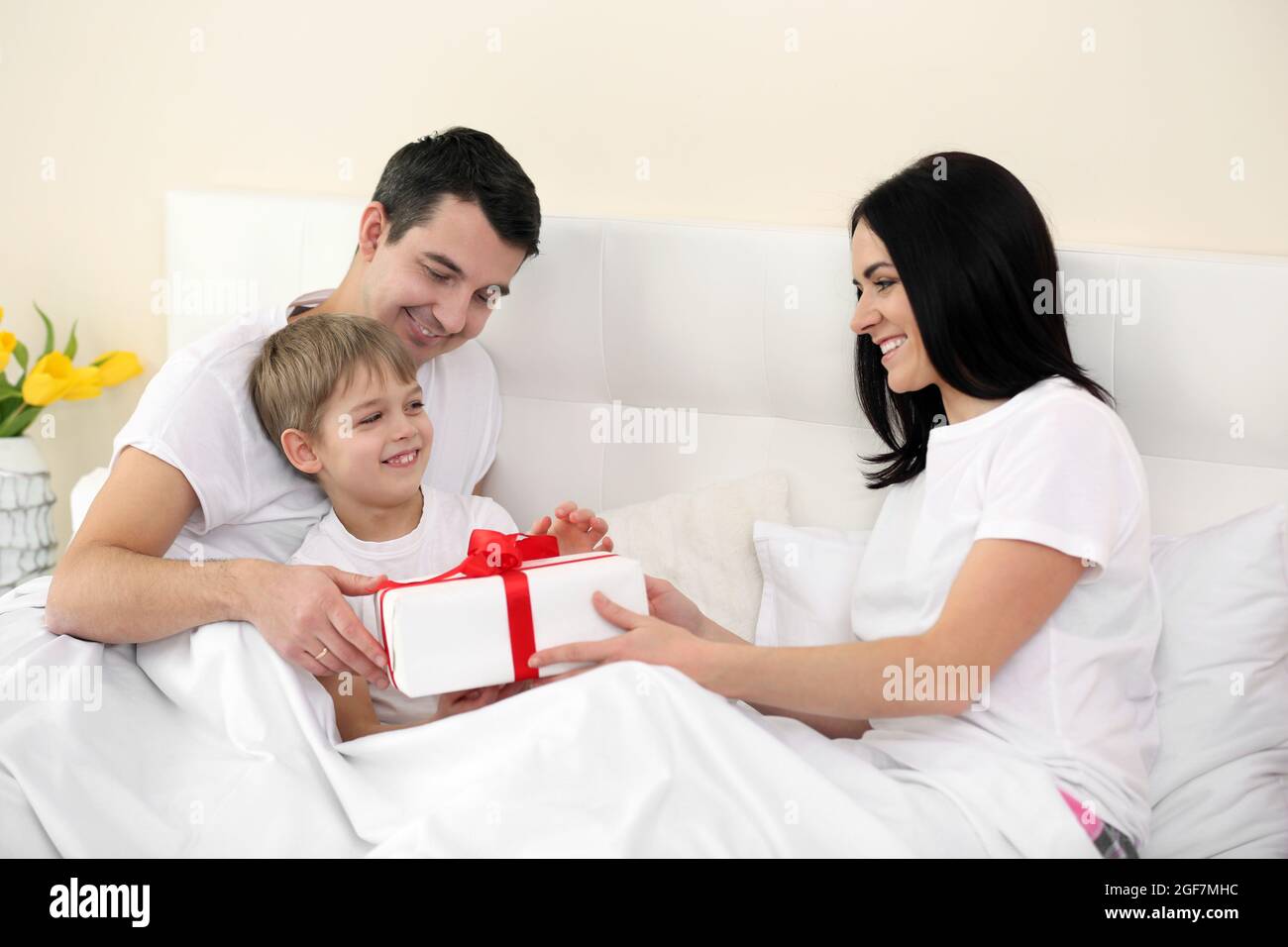 Ehemann und Sohn, die der Frau für den Muttertag im Bett Geschenk machen  Stockfotografie - Alamy