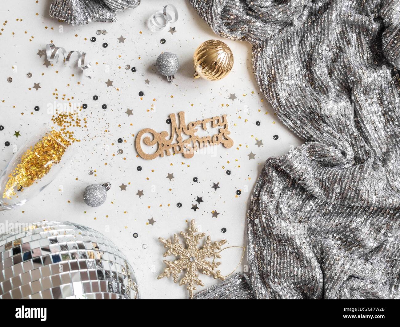 Flaches Lay von Weihnachten Party Disco Ball, Kleid, Saison Dekoration und wünschen Ihnen frohe Weihnachten auf weißem Hintergrund. Draufsicht Stockfoto