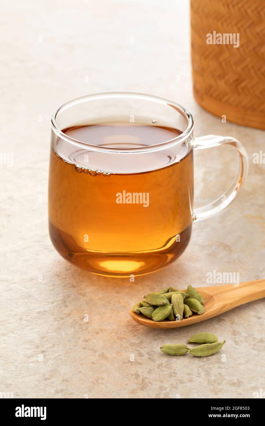 Gesunder Cardamom-Tee mit einem Löffel grüne Kardamom-Schoten davor Stockfoto