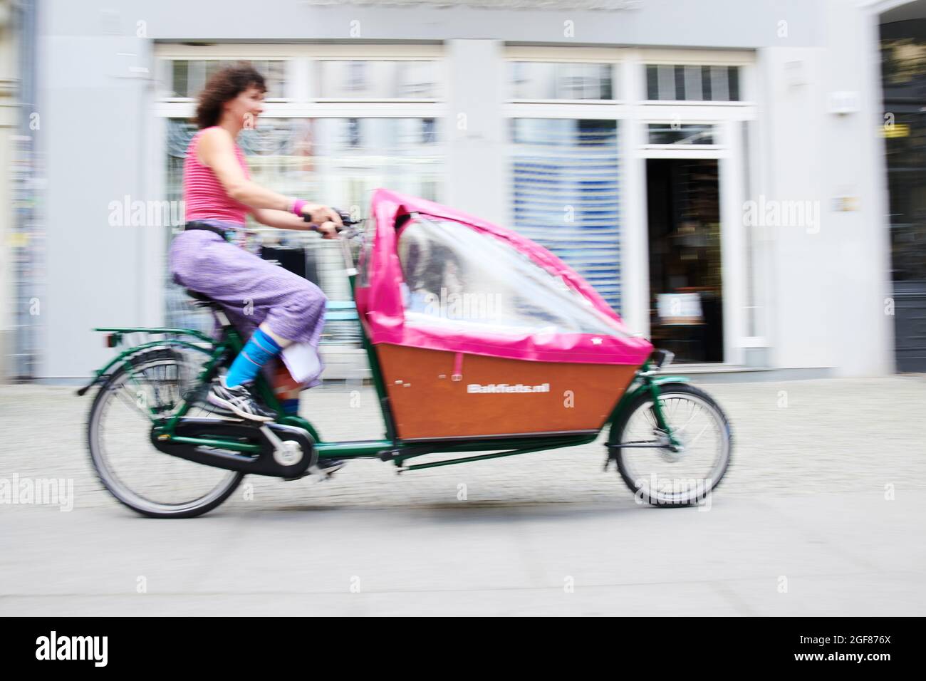 Berlin, Deutschland. August 2021. Eine Frau fährt auf einem Radweg mit dem Lastenrad. Seit dem Vorschlag der Grünen, den privaten Kauf von Lastenrädern landesweit zu fördern, wurde über deren Nutzen diskutiert. (Illustration für dpa: 'Das Packmuli ist jetzt ein politisches Thema: Das ist der Zustand des Lastenrads') Quelle: Annette Riedl/dpa - ACHTUNG: Nur für redaktionelle Verwendung im Zusammenhang mit der aktuellen Berichterstattung und nur mit vollständiger Erwähnung der obigen credit/dpa/Alamy Live News Stockfoto