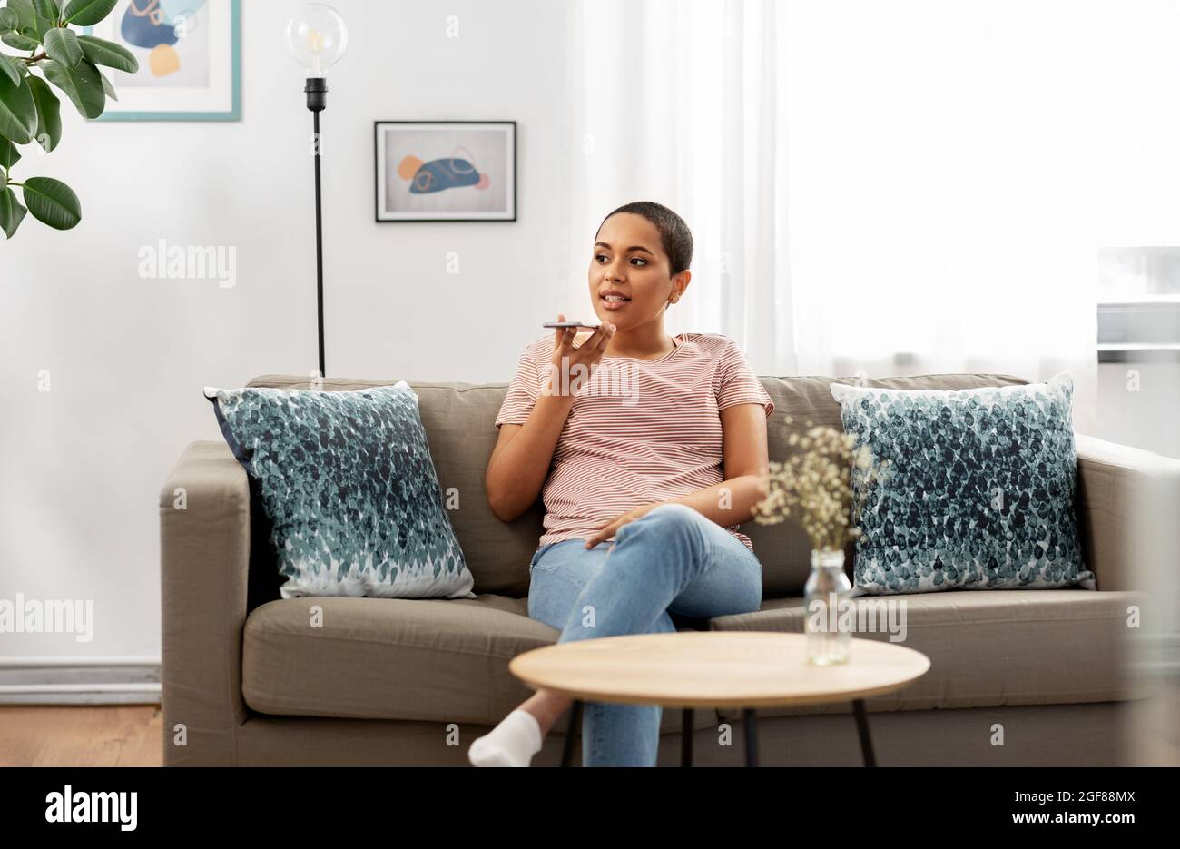 Frau, die zu Hause mit dem Smartphone sprach Stockfoto