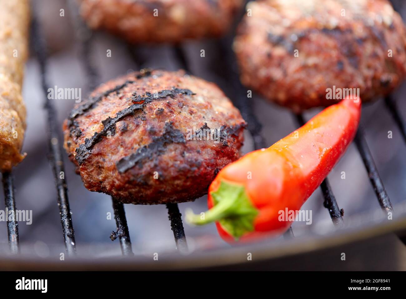 burger-Fleischschnitzel und Pfefferrösten auf dem Grill Stockfoto