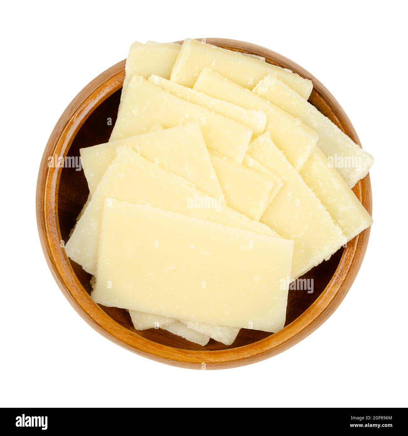 Dünne Grana Padano-Käsescheiben, in einer Holzschüssel. Italienischer Hartkäse, ähnlich wie Parmesan, krümelig strukturiert, mit kräftigem herzhaften Geschmack. Stockfoto