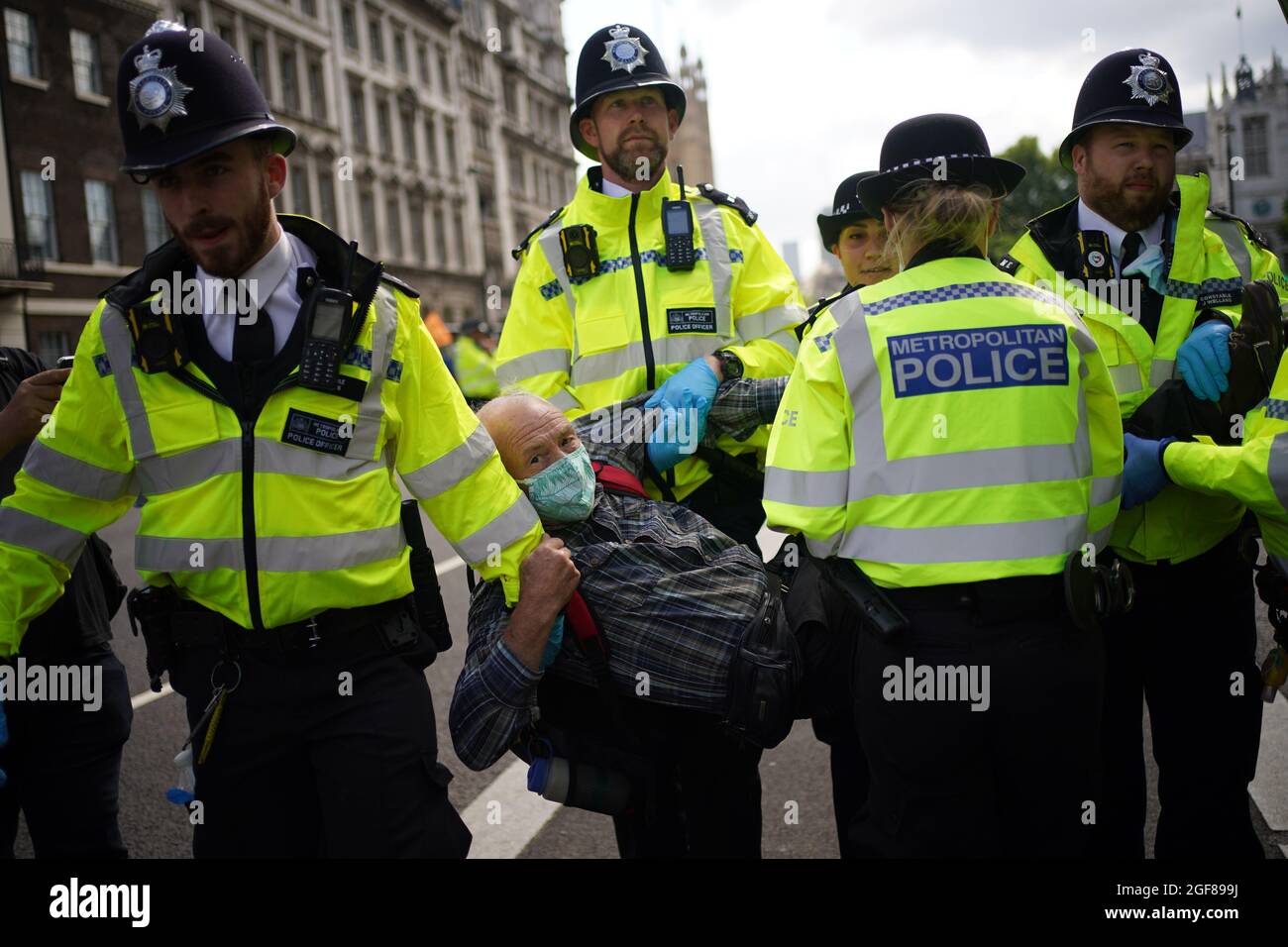 Die Polizei bringt einen Demonstranten während eines Protestes von Mitgliedern des Extinction Rebellion in Whitehall, im Zentrum von London, mit. Bilddatum: Dienstag, 24. August 2021. Stockfoto