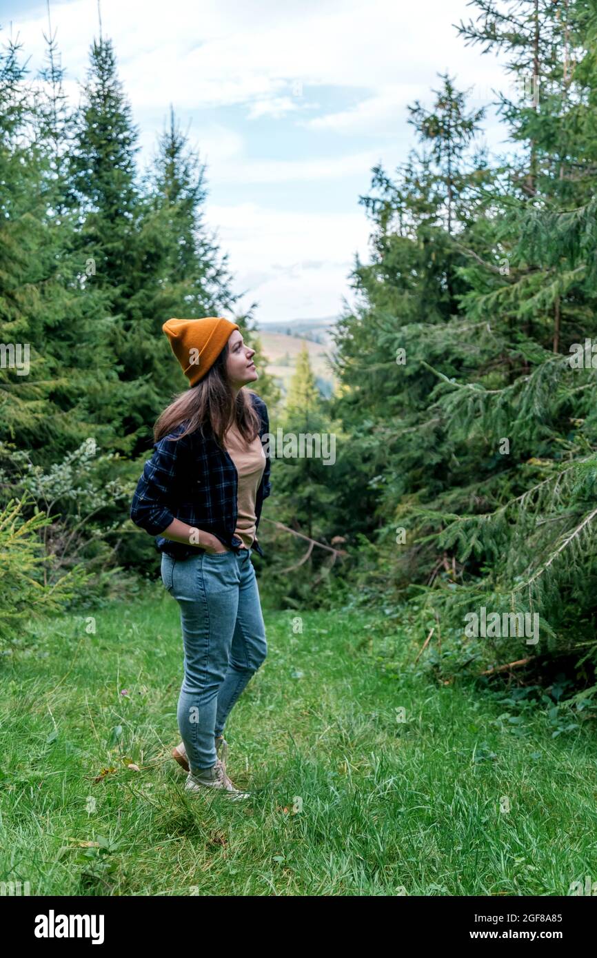 Schöne Frau, die in den Bergen wandert. Natur Freizeitaktivitäten im Wald. Kaukasische Frau Porträt Hipster in Hut auf Berglandschaft. Stockfoto