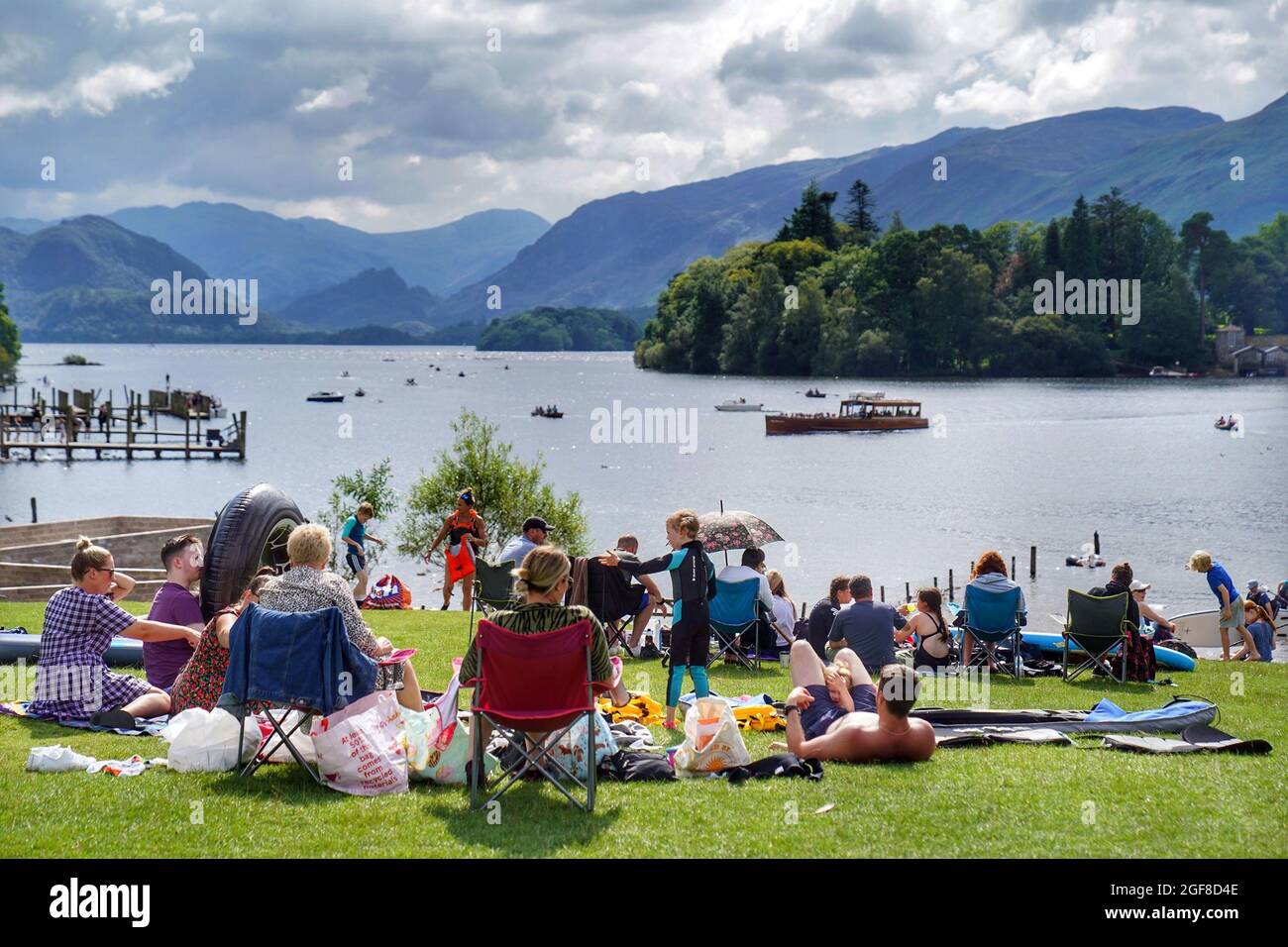 Beim Sonnenbaden im Crow Park am Ufer des Derwentwater im Lake District werden Besucher von Cumbria gebeten, einen lateralen Durchflusstest durchzuführen, bevor sie nach einem starken Anstieg der Coronavirus-Fälle in der Region in die Grafschaft reisen. Bilddatum: Dienstag, 24. August 2021. Stockfoto