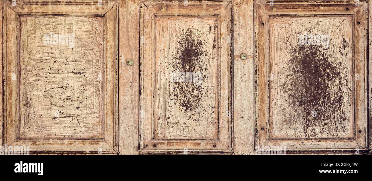 Banner von einer alten beigen und rostigen Tür mit drei zerkratzten Rahmen Stockfoto