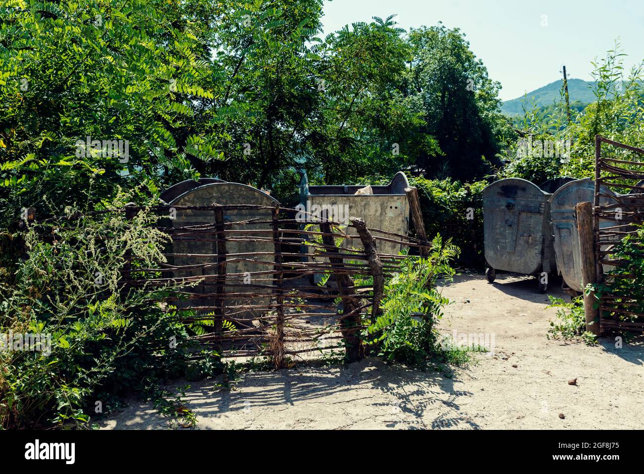Ein Ort für die organisierte Abfallsammlung in Containern, umgeben von einem Zaun in einem bulgarischen Bergdorf Stockfoto