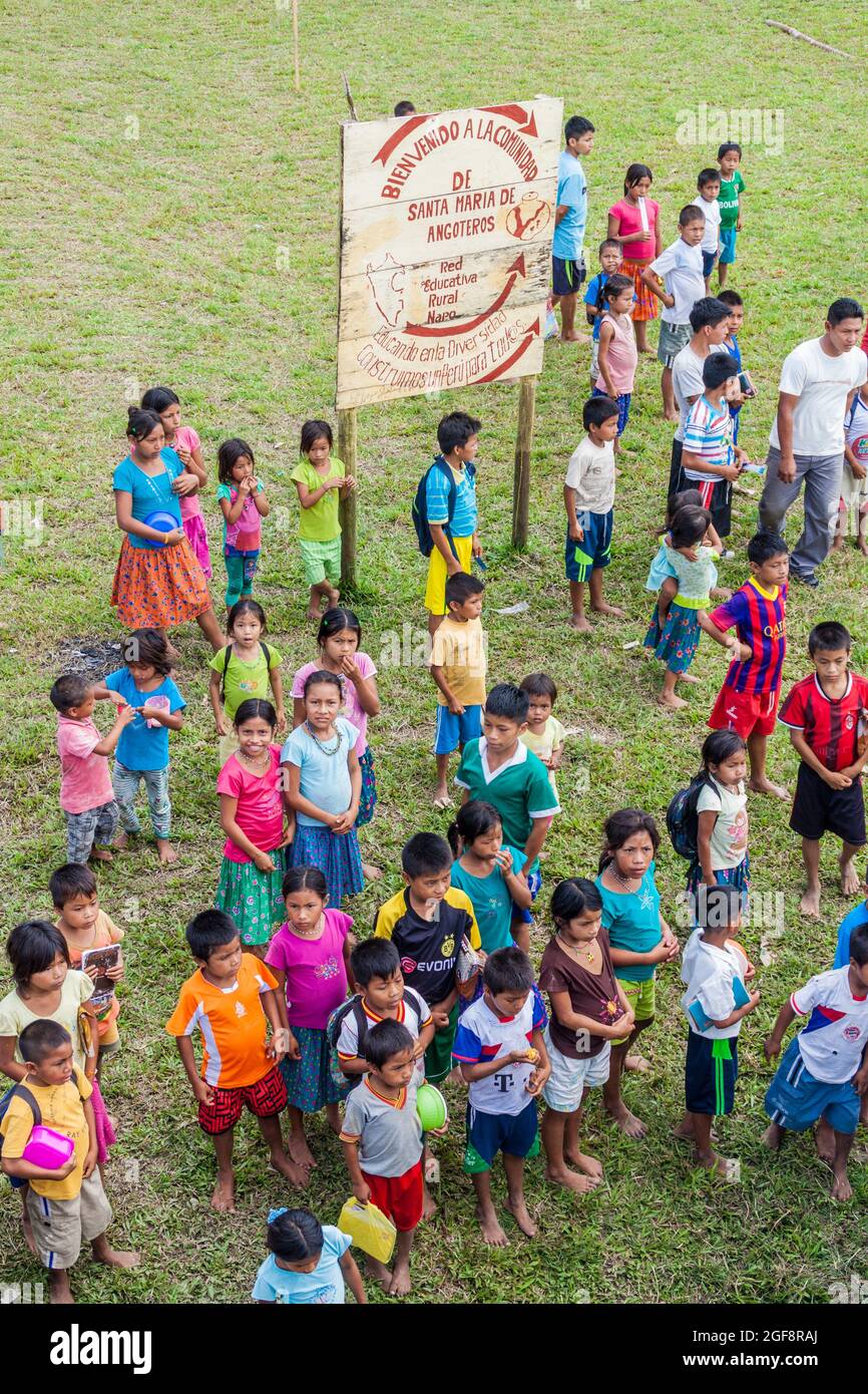 SANTA MARIA DE ANGOTEROS, PERU - 15. JULI 2015: Kinder des Dorfes Santa Maria de Angoteros beobachten ein Boot, das auf einem Fluss Napo ankommt. Stockfoto