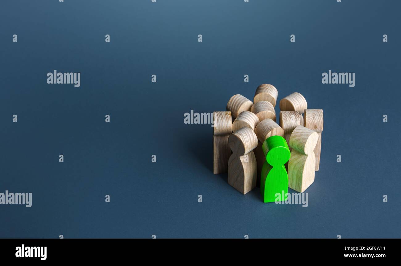 Ein grüner Mann steht in einer Menschenmenge. Einstellung eines talentierten Kandidaten. Suchen Sie nach einer Person. Vielversprechend. Wertvoller Mitarbeiter. Beförderung am Arbeitsplatz, Karriere Stockfoto