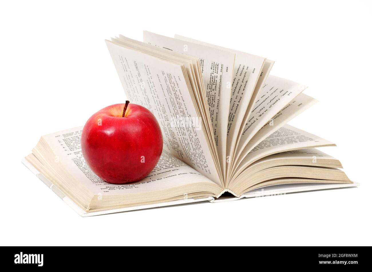 roter Apfel auf ein Buch, isoliert auf weiss Stockfoto