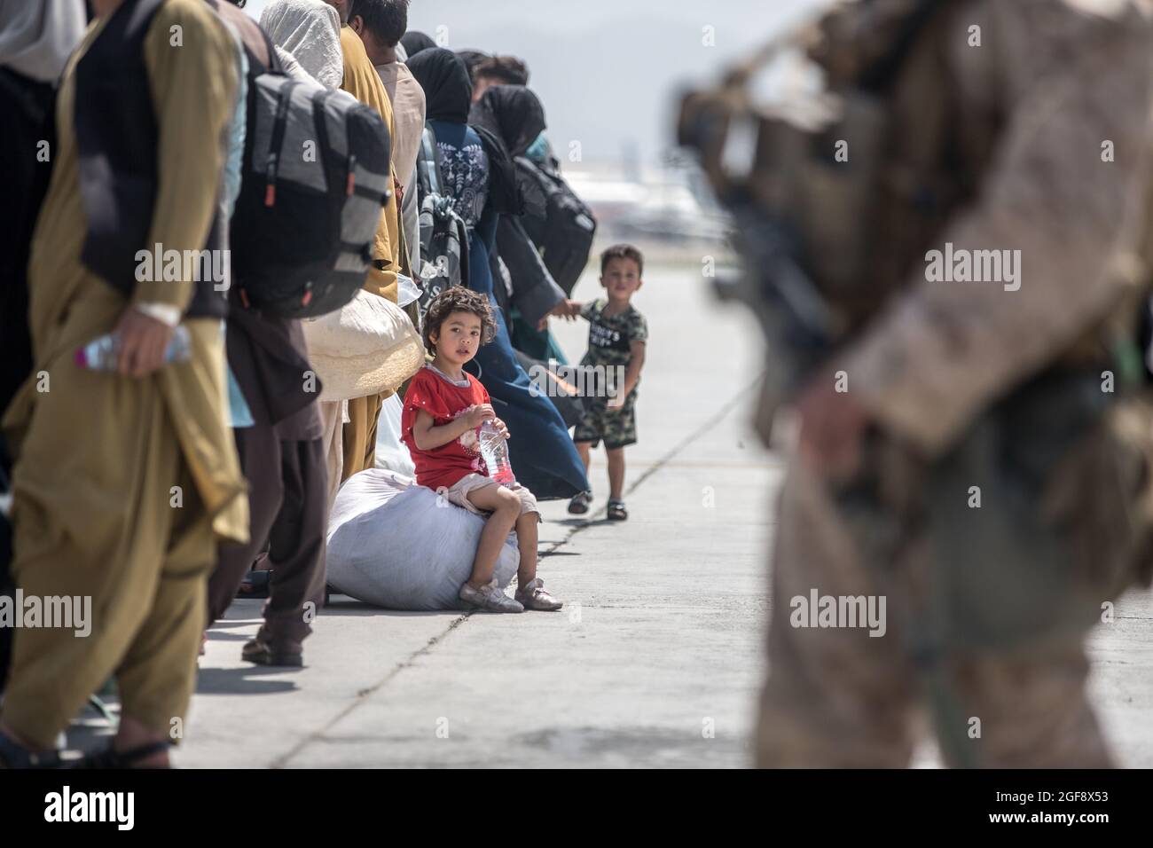 Afghanische Familien warten während der Evakuierung auf dem Hamid Karzai International Airport während der Operation Allies Refuge am 22. August 2021 in Kabul, Afghanistan, auf den Einsatz eines Globemaster III-Flugzeugs der US-Luftwaffe C-17. Stockfoto