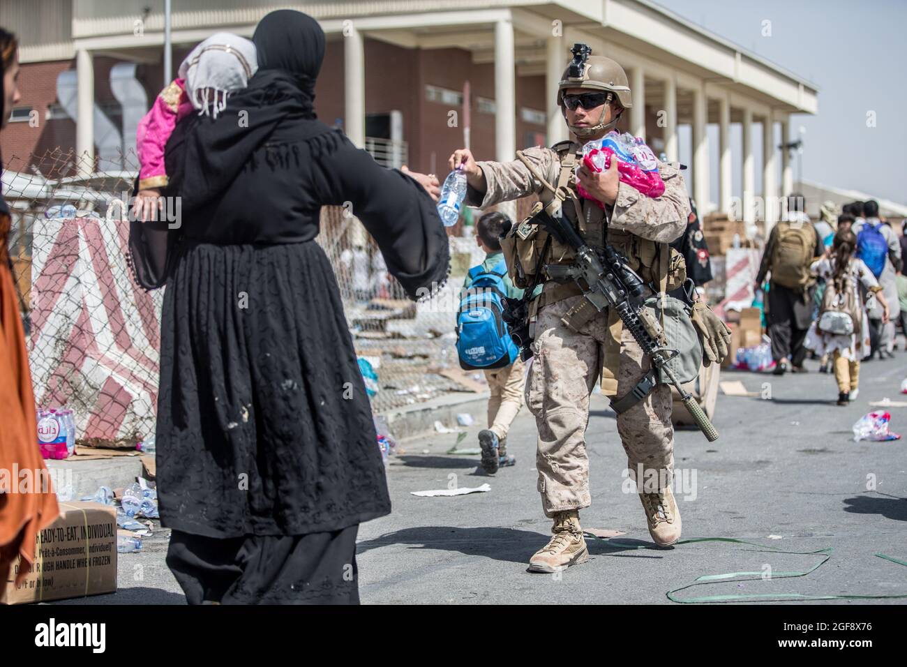 Eine US-Marine mit dem Special Purpose Marine Air-Ground Task Force/Crisis Response Team gibt während der Evakuierung am Hamid Karzai International Airport während der Operation Allies Refuge am 22. August 2021 in Kabul, Afghanistan, abgefülltes Wasser aus. Stockfoto