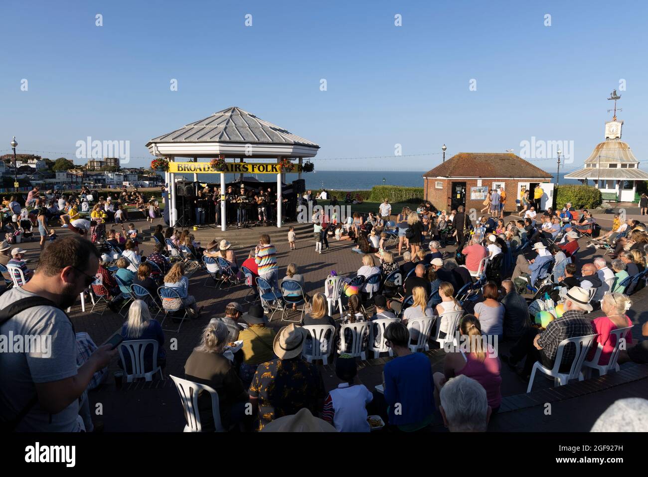 Menschen, die einer Ukulele-Band zuhören, die während der Broadstairs Folk Week, August 2021, am Bandstand auftrat Stockfoto