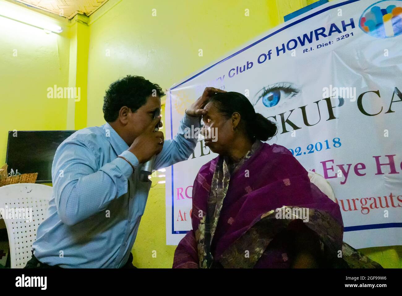 KALKUTTA , INDIEN - 25. FEBRUAR 2018 : Augenarzt Augenarzt Kontrolle Augen der erwachsenen Frau auf einem Stuhl sitzen, bei einem kostenlosen öffentlichen Auge Tests Stockfoto