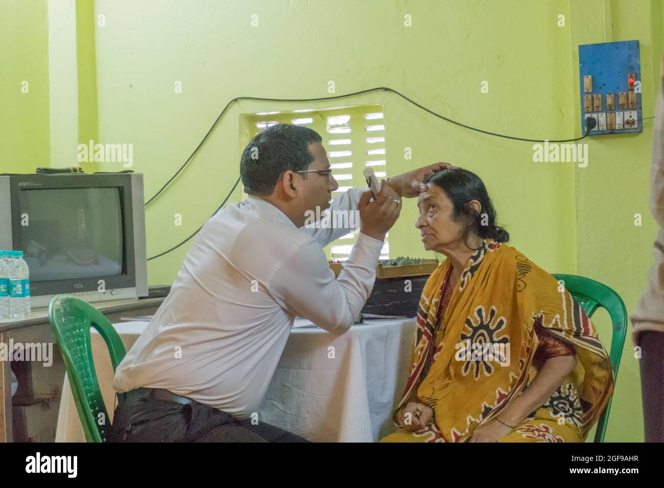 KOLKATA , INDIEN - 19. MÄRZ 2017 : Augenarzt, Augenarzt, der die Augen der erwachsenen Frau auf einem Stuhl in einem kostenlosen öffentlichen Testlager überprüft Stockfoto