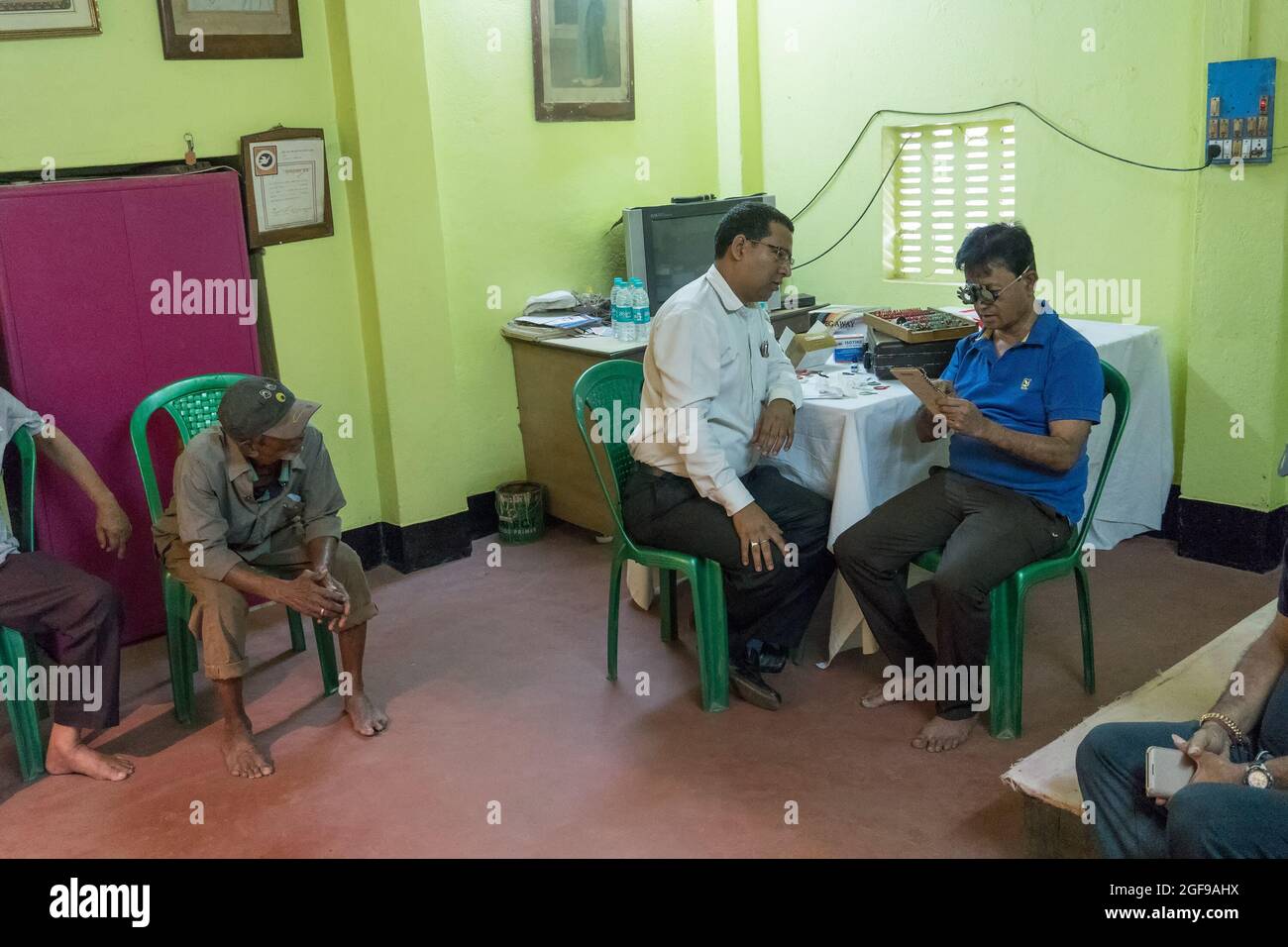 KOLKATA , INDIEN - 19. MÄRZ 2017 : Augenarzt, Augenarzt, der die Augen eines erwachsenen Mannes auf einem Stuhl in einem kostenlosen öffentlichen Testlager überprüft. Stockfoto