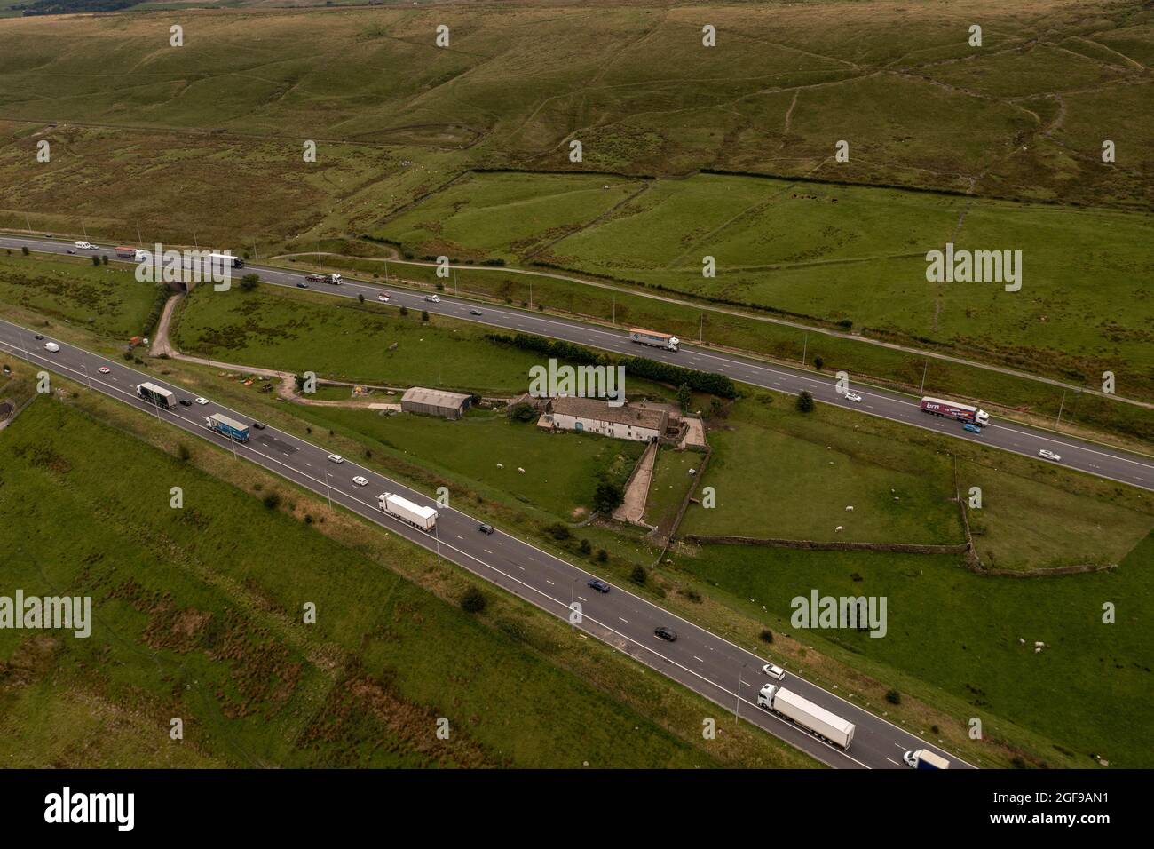 Rishworth Moor Motorway Ainley Top M62 Stott Hall Farm Aerial Birds Eye View das Haus in der Mitte der Straße wurde die Autobahn M62 herum gebaut Stockfoto