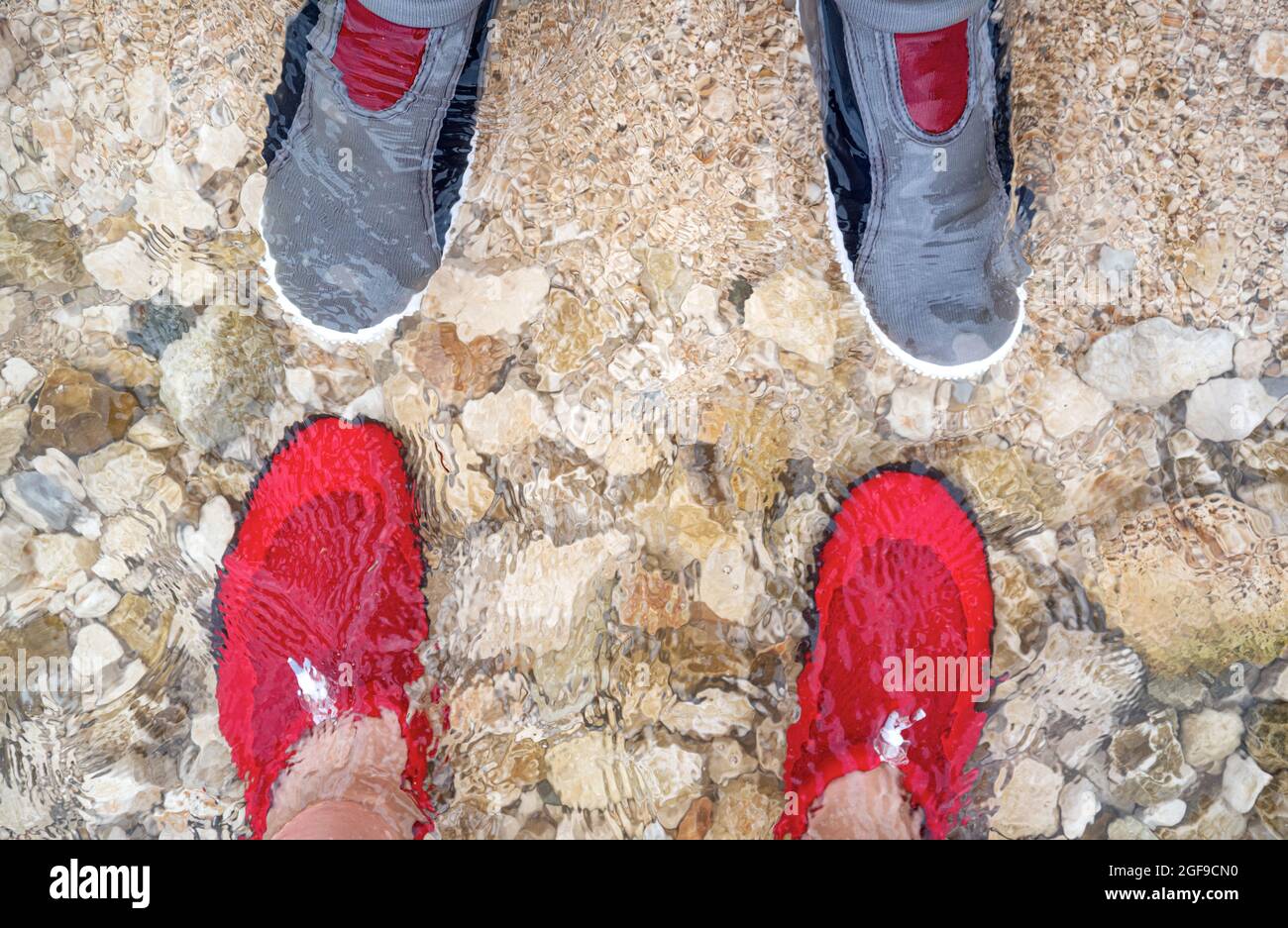 Männliche und weibliche Füße in Badeschuhen. Stockfoto