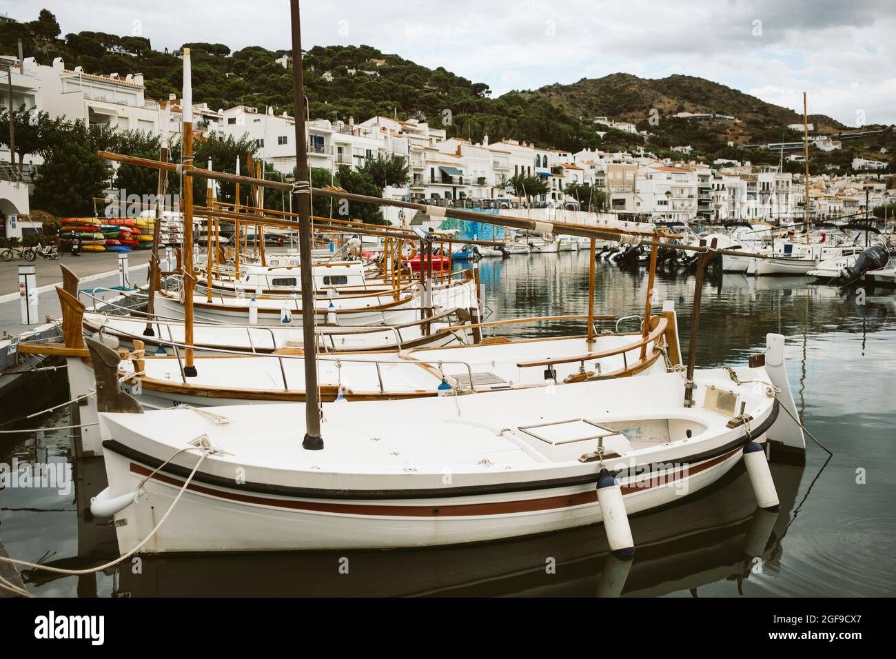 Blick auf die kleine spanische Stadt Port de la Selva Hafen an der Costa Brava in Katalonien, mit kleinen weißen Fischerbooten an einem bewölkten Sommertag während zu Stockfoto