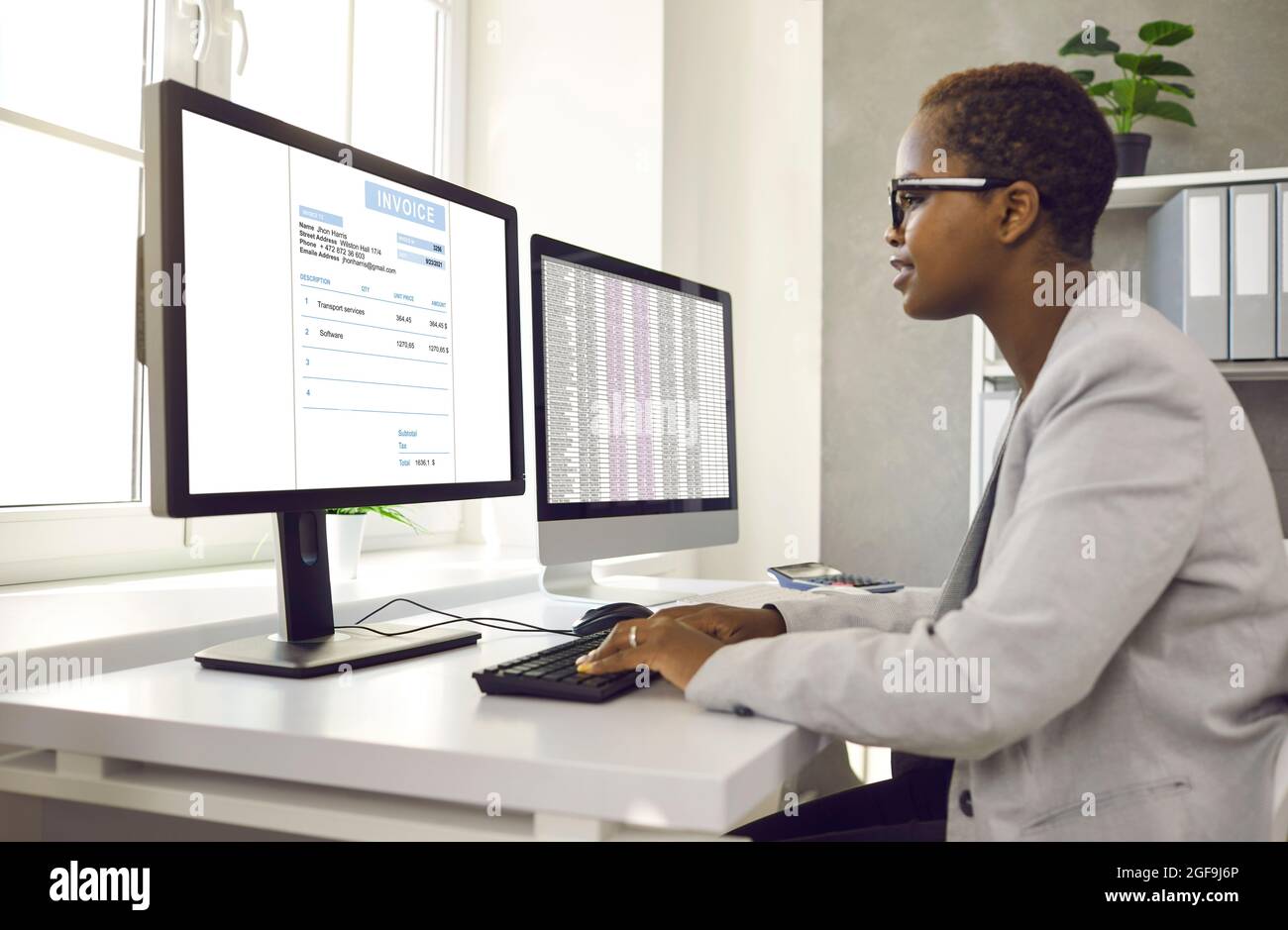 Afroamerikanische Buchhalterin, die mit Software für elektronische Rechnungen am Computer arbeitet. Stockfoto