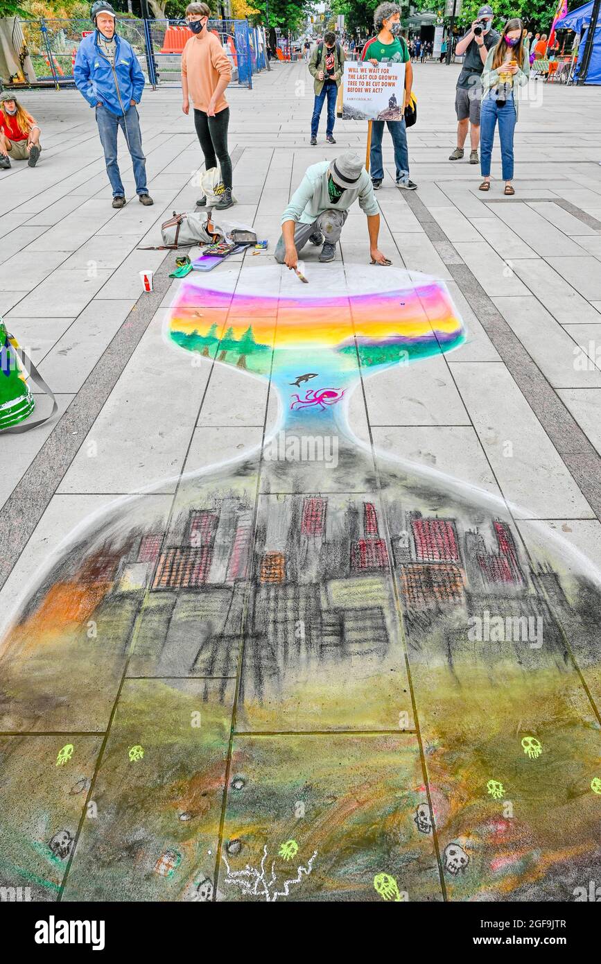 Extinction Rebellion Supporter macht Kalk-Kunst aus Sanduhr mit der Zeit läuft aus, , Vancouver, British Columbia, Kanada Stockfoto
