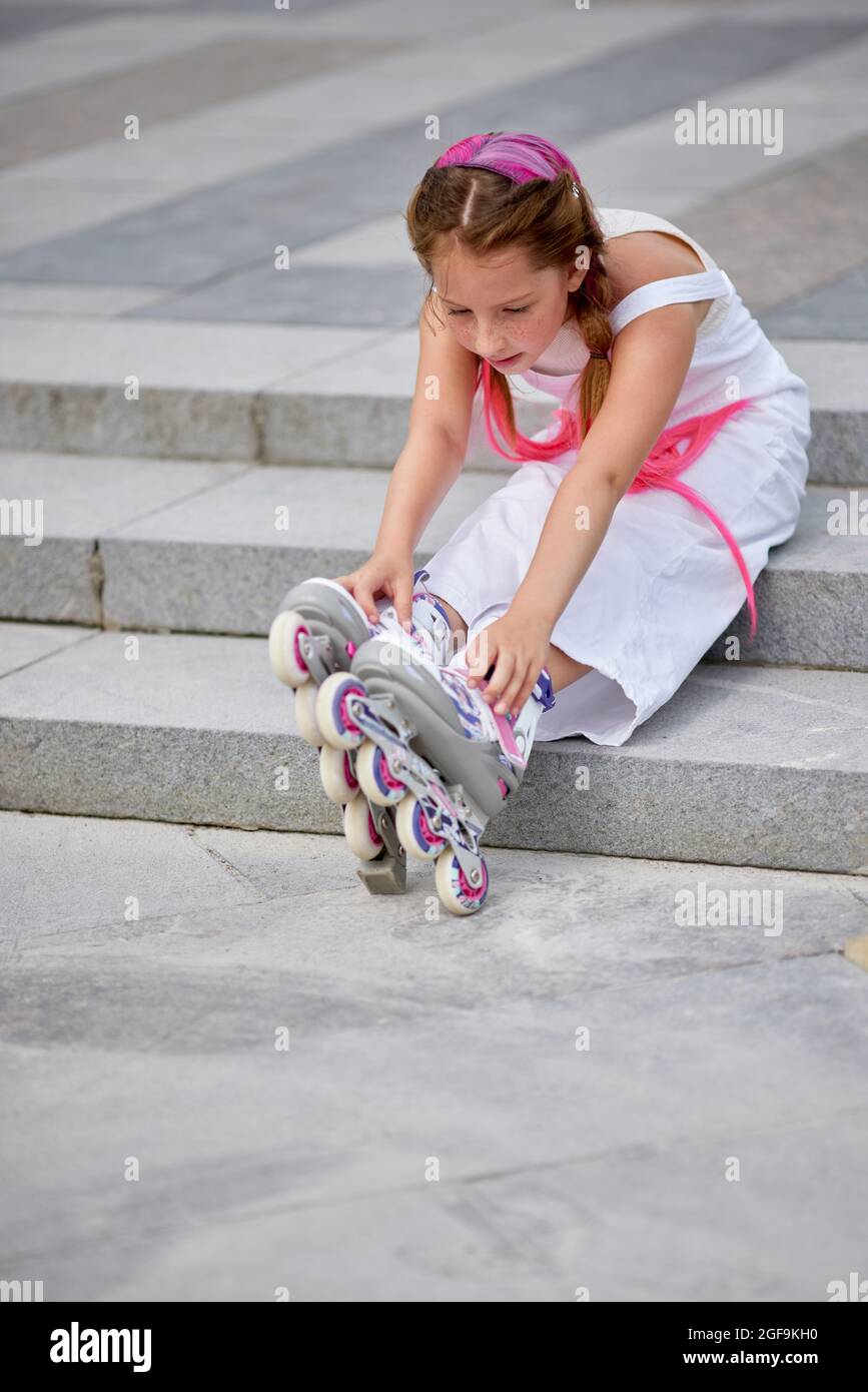 Nettes kleines Mädchen auf Rollschuhe im Park. Stockfoto